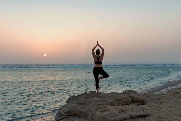 Frau macht Yoga am Strand des Mövenpick Resorts El Quseir.