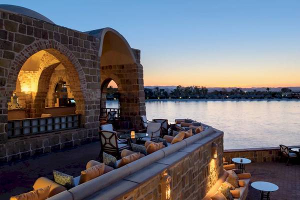 Außenbereich des Mövenpick Resorts El Quseir bei Sonnenuntergang mit Blick auf den See.
