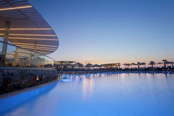Außenpool des Arina Beach Resorts bei Sonnenuntergang mit blau beleuchtetem Wasser