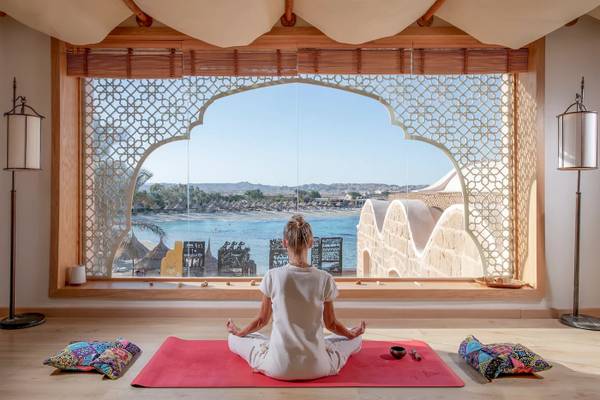 Frau praktiziert Yoga und Meditation im Mövenpick Resort El Quseir mit Blick auf das Meer.