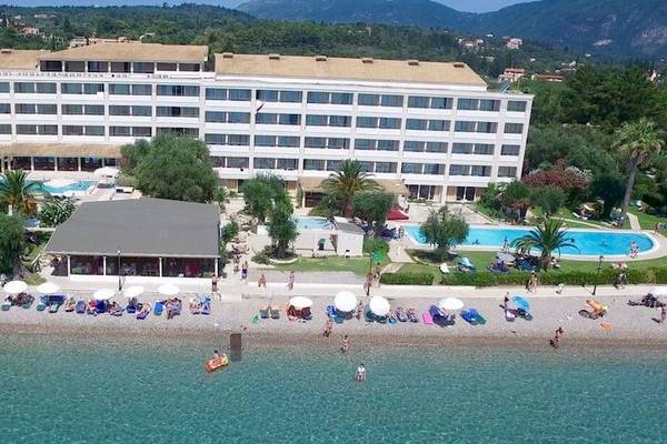Außenansicht des Elea Beach Hotels mit vielen Gästen am Strand und im Schwimmbad.