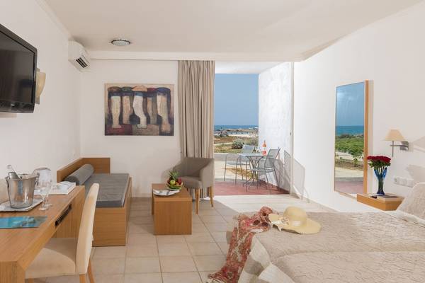 Innenansicht des Hotelzimmers im Arina Beach Resort mit Meerblick, Fernseher, Gemälde und Einrichtung.
