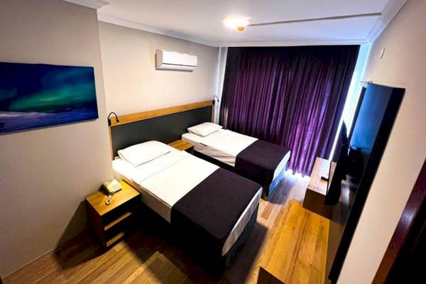 Doppelzimmer im Club Wasa Holiday Village mit zwei Betten, Fernseher und Nachttischen.