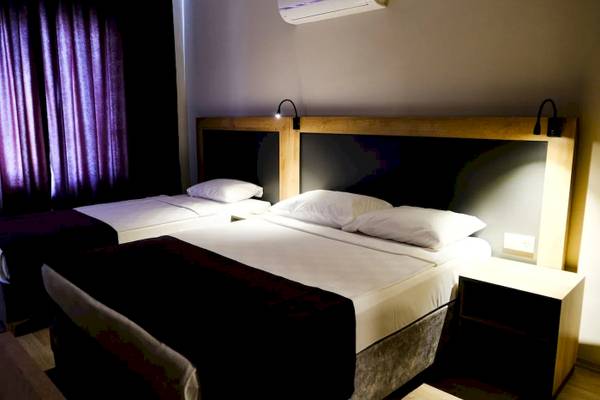 Doppelbett-Zimmer im Club Wasa Holiday Village mit zwei Betten, Kissen und Nachttischen.