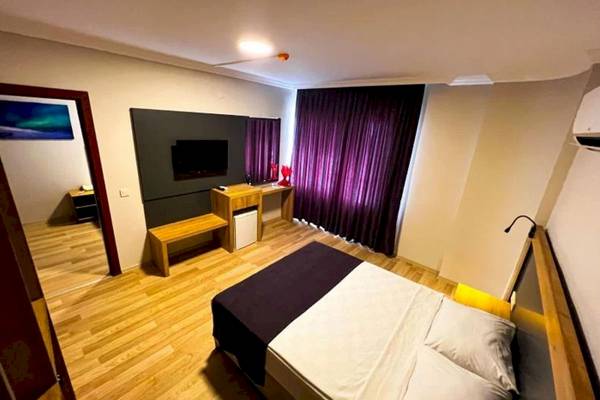 Innenansicht eines Zimmers im Club Wasa Holiday Village mit Doppelbett, Fernseher und Schreibtisch