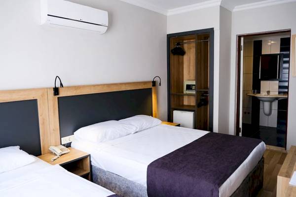 Doppelzimmer im Club Wasa Holiday Village mit zwei Betten, Telefon und Klimaanlage.