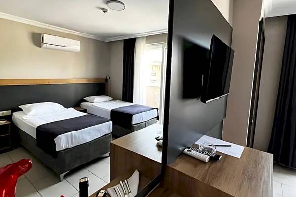 Doppelzimmer im Club Wasa Holiday Village mit zwei Betten und Fernseher.