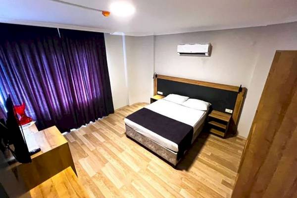 Ein Hotelzimmer im Club Wasa Holiday Village mit einem Bett, Fernseher und Klimaanlage.
