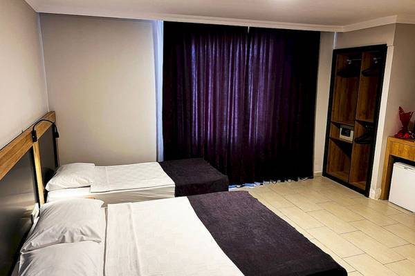 Zwei Betten in einem Club Wasa Holiday Village Zimmer mit weißen Laken und Kissen.