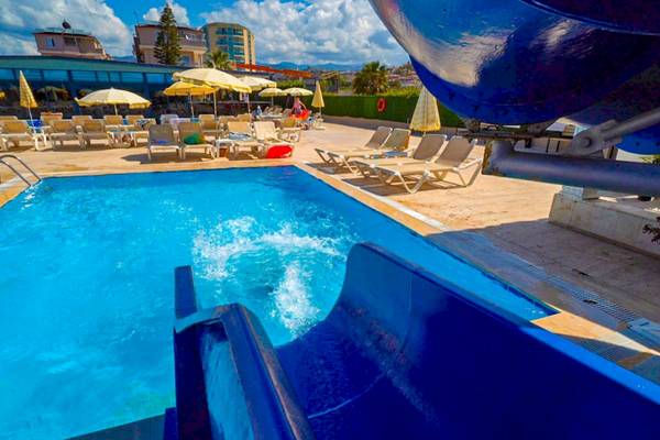 Poolrutsche im Club Wasa Holiday Village mit Sonnenliegen und Sonnenschirmen.