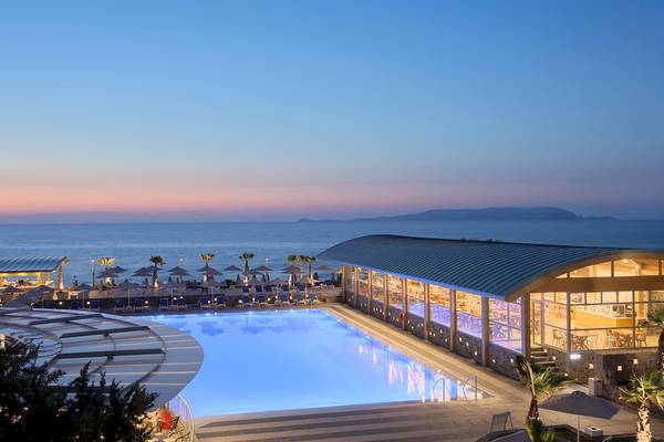 Außenansicht des Arina Beach Resorts mit Swimmingpool und Meerblick bei Sonnenuntergang.