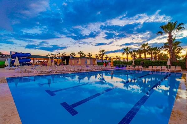 Poolbereich des Club Wasa Holiday Village mit Liegestühlen und Sonnenschirmen