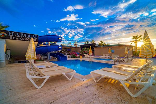 Poolbereich des Club Wasa Holiday Village mit Rutsche und Sonnenliegen