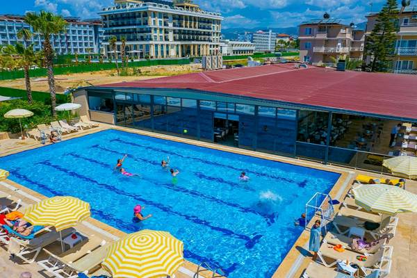 Überblick über den Poolbereich des Club Wasa Holiday Village mit mehreren Schwimmern.
