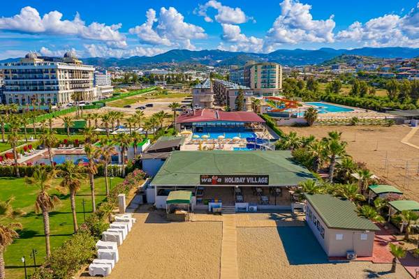 Luftaufnahme des Club Wasa Holiday Village mit mehreren Gebäuden, Pools und Wasserrutschen.