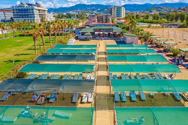 Luftaufnahme des Club Wasa Holiday Village mit Sonnenliegen und überdachten Bereichen.