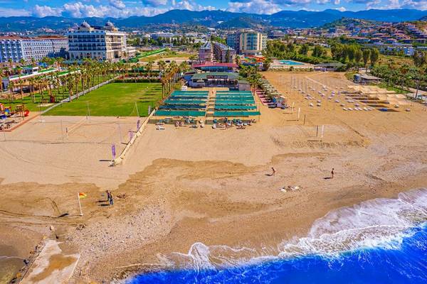 Luftaufnahme des Club Wasa Holiday Village Strands mit Hotels, Palmen und Wellen