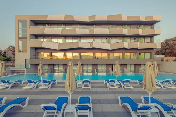 Außenbereich des Arina Beach Resorts mit Pool und Sonnenliegen.