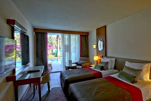 Doppelzimmer mit zwei Betten, Schreibtisch, Fernseher, Terrasse und Poolblick im Side Star Elegance Hotel.