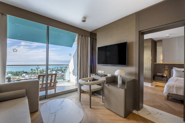 Innenansicht einer Suite im Side Star Elegance Hotel mit Meerblick, Flachbildfernseher und gemütlichem Möbel.