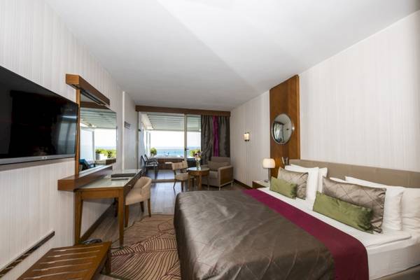 Schlafzimmer im Side Star Elegance Hotel mit großem Bett, Fernseher und Meerblick.