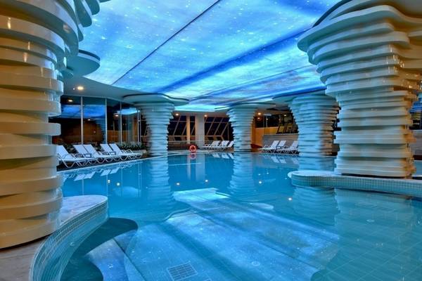 Innenpool im Side Star Elegance Hotel mit blauer Sternenhimmel-Decke und weißen Säulen.