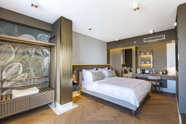 Innenansicht eines Hotelzimmers im Side Star Elegance mit Doppelbett, Kleiderschrank und Badezimmerspiegel.