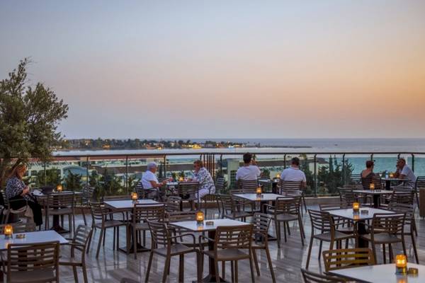 Gäste sitzen auf der Terrasse des Side Star Elegance Hotels bei Sonnenuntergang.