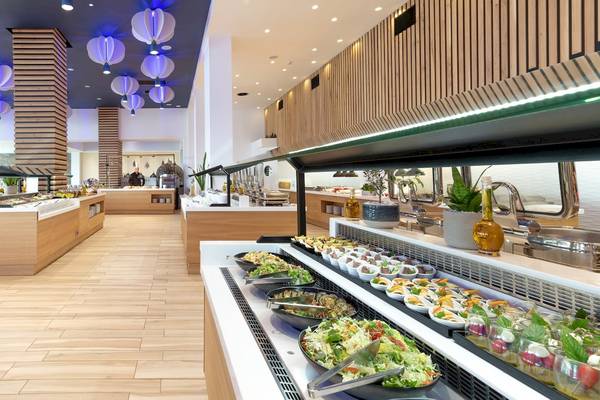 Innenraum des Arina Beach Resorts mit Buffet-Tisch, Holzboden und Beleuchtung.