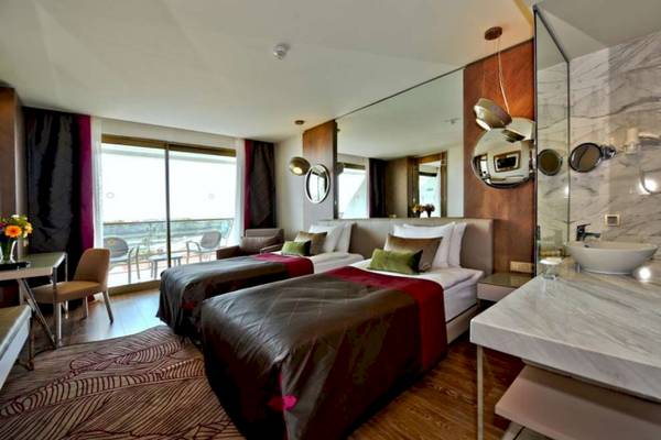 Doppelbett-Hotelzimmer mit modernem Design, Marmorboden und großen Fenstern.