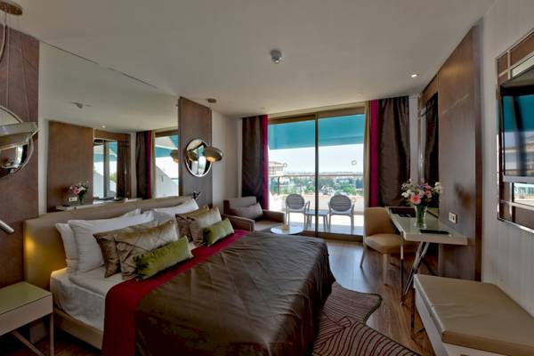 Schlafzimmer im Side Star Elegance Hotel mit großem Bett und Ausblick auf die Stadt.
