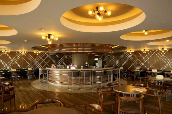 Innenansicht der Bar im Side Star Elegance Hotel mit Bartisch, Stühlen und dekorativen Kronleuchtern.