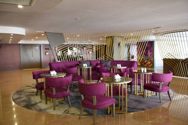 Loungebereich des Side Star Elegance Hotels mit violetten Stühlen und goldenen Tischen.