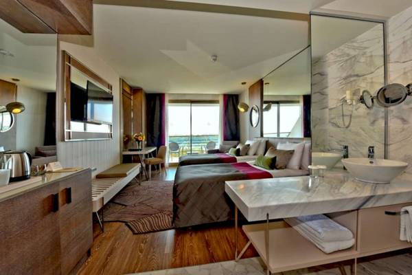 Foto von einem eleganten Schlafzimmer in der Side Star Elegance Hotel Suite mit zwei Betten und Meerblick.