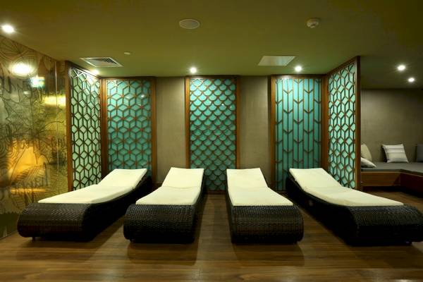 Vier schwarze und weiße Liegen im Wellnessbereich des Side Star Elegance Hotels.