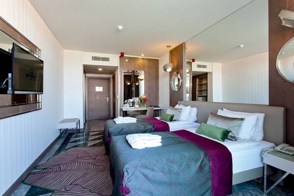Doppelzimmer im Side Star Elegance Hotel mit zwei Betten, Fernseher, Spiegeln und Nachttischen.