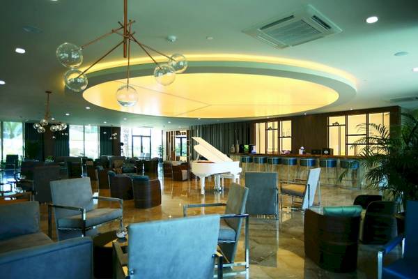 Lobby-Bereich des Side Star Elegance Hotels mit einem weißen Klavier und Sitzgelegenheiten.