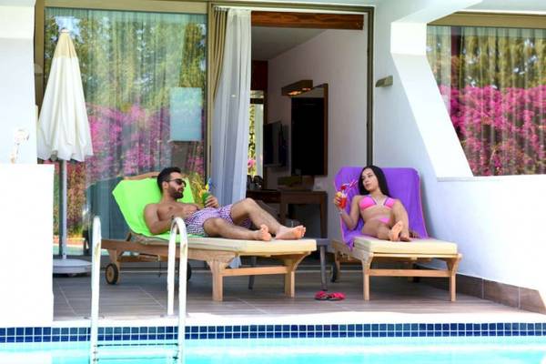 Mann und Frau auf Liegen am Pool im Side Star Elegance Hotel