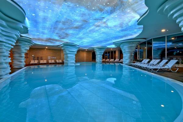 Innenpool des Side Star Elegance Hotels mit Sternenhimmelprojektion an der Decke und geometrischen Säulen.