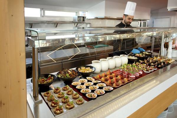 Ein Koch im Arina Beach Resort serviert eine Auswahl an Speisen auf einem Buffet.
