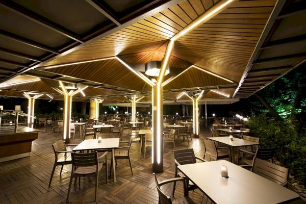 Außenterrasse des Side Star Elegance Hotels bei Nacht mit illuminierten Säulen und Tischen.