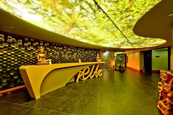 Lobby des Side Star Elegance Hotels mit gelbem Schreibtisch und Buddha-Statuen.