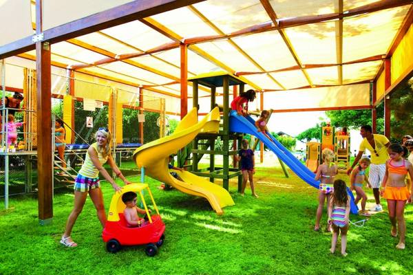 Kinder spielen auf einem Spielplatz im Freien im Hotel Side Star Elegance, mit Rutschen und einem Auto.
