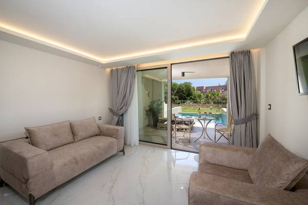 Wohnbereich eines Hotels mit zwei Sofas und einer Terrasse mit Tisch und Stühlen