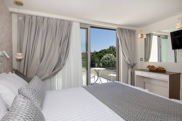 Hotelzimmer mit Balkon und Aussicht auf einen Garten und Terrasse.