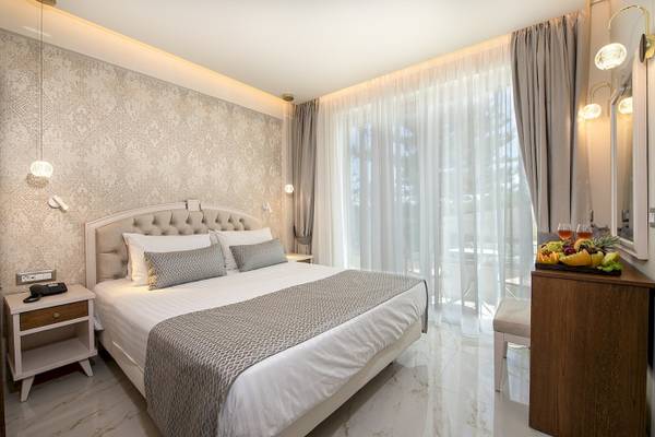 Schlafzimmer im Vantaris Luxury Beach Resort mit Bett, Obstplatte und Balkon