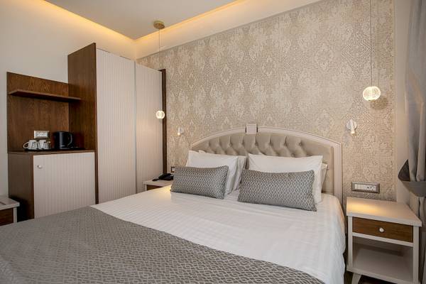 Hotelzimmer mit Doppelbett, Nachttischen und Wanddekoration.