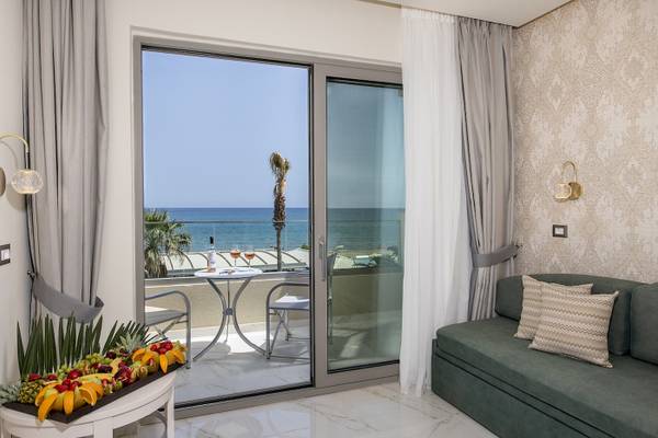 Balkon im Vantaris Luxury Beach Resort mit Blick auf das Meer und eine Obstschale.
