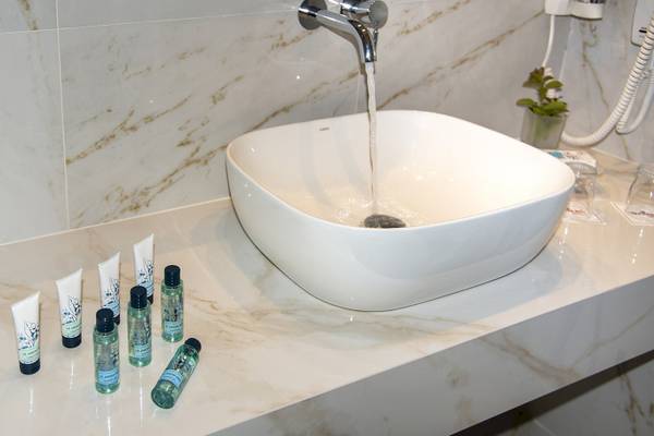 Waschbecken im Badezimmer des Vantaris Luxury Beach Resorts mit Wasserhahn und Pflegeprodukten.