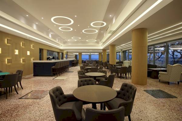 Innenbereich der Lounge im Arina Beach Resort mit vielen Tischen und Stühlen.
